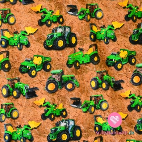 Gestrickter grüner Traktor auf einem Feld mit Getreide
